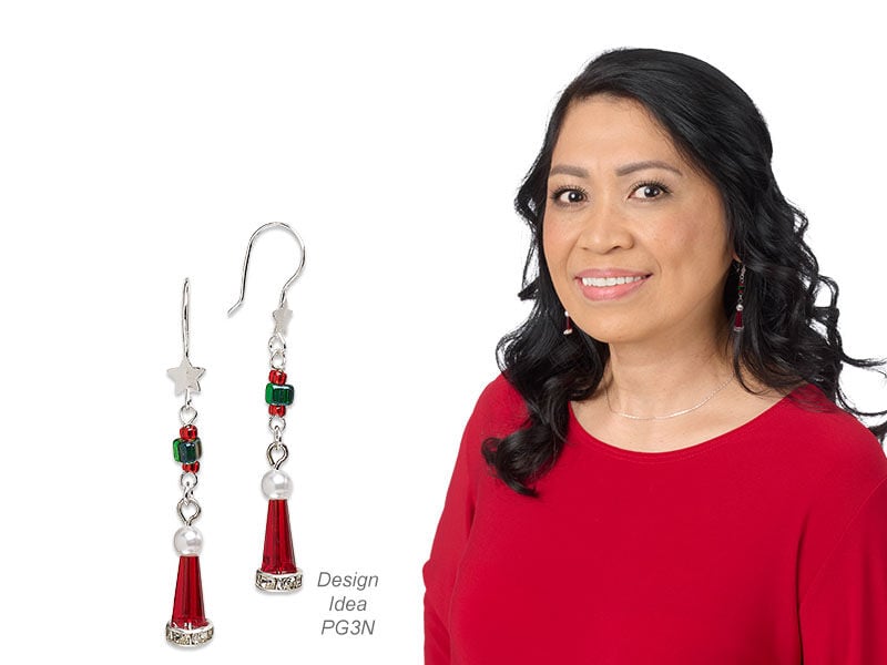 Model wearing earrings that look like santa hats