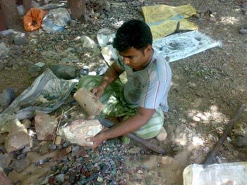 Man with a wooden mallet and a stone